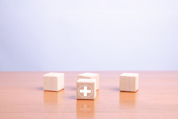Wooden blocks with a highlighted plus symbol representing positivity, leadership, selection, and growth concepts in business strategy, decision-making, and personal development