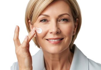 Smiling mature woman applying hydrating face cream to her cheek