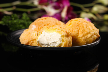 Fresh cream puffs with milk cream filling dessert pastry balls in bowl