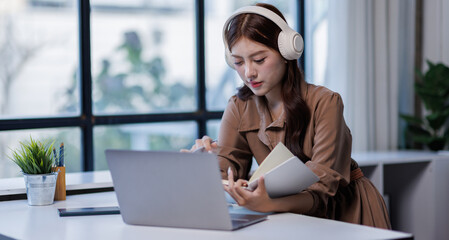 Laptop, business and remote work with asian womanlistening music from headphones in office 
