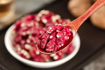 Red-skinned Xinjiang walnut kernels on wooden spoon - premium quality nuts with natural coating