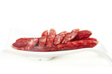 Air-dried spicy sausage slices with rich flavor on white plate - traditional cured meat delicacy