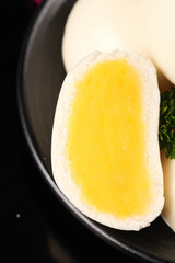 Soft boiled egg with golden runny yolk and creamy texture on dark plate - gourmet breakfast food photography