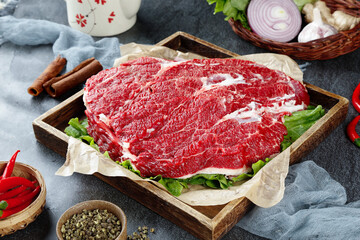 Raw Beef Brisket Cut on Wooden Tray with Fresh Vegetables and Cooking Spices