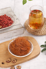 Corn silk herbal tea brewing ingredients with goji berries and natural wellness drinks setup