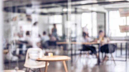 A blurred view of a modern workspace with people collaborating, emphasizing a dynamic, creative environment.