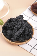 Xinjiang Black Raisins in Wooden Bowl - Premium Dried Fruit Display on Kitchen Counter