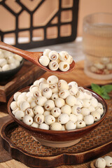 Dried lotus seeds with heart removed in wooden bowl - white Asian cooking ingredients