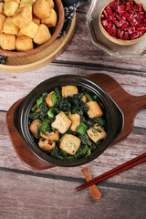 Delicious stir-fried tofu puffs with greens Asian cuisine cooking ingredients on wooden table