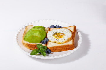 Avocado Toast and Egg in Hole Breakfast with Blueberries - Healthy Morning Meal