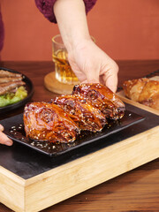 Chef preparing sesame glazed rabbit head dish Chengdu Shuangliu traditional Chinese cuisine cold appetizer showcase