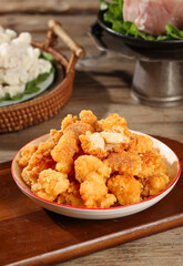 Golden Crispy Fried Cauliflower Nuggets on Wooden Table - Healthy Vegetarian Snack Food