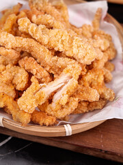 Crispy Fried Chicken Strips in Bamboo Basket - Golden Breaded Poultry Snacks on Wooden Board