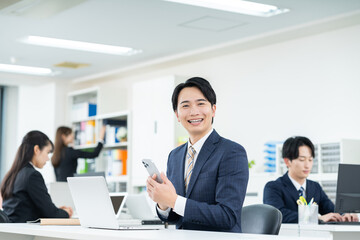 Fototapeta premium オフィスで働く若いビジネスマン