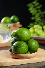 Fresh Green Limes from Taiwan Hainan Estates Perfumed Seedless Variety in Wooden Bowl on Cutting Board
