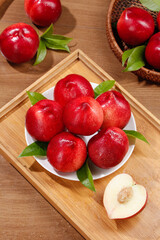 Fresh Red Nectarines on White Plate with Heart-Shaped Cut Piece and Green Leaves