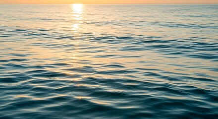 The picture shows a beautiful natural landscape with green hills and a clear blue sky. In the middle of the field, a group of deer is grazing peacefully. Tall trees surround the area, and a small rive