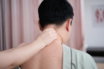Fototapeta premium Asian mature male patient is neck massaging, muscle stretching, and recovery for pain relief, healing by physical therapist doctor's hand, passive medical therapy at healthcare wellness spa clinic.