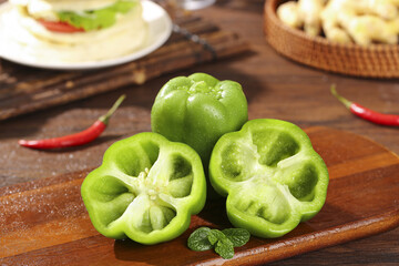 Fresh Green Bell Peppers and Spicy Red Chili Peppers on Wooden Cutting Board - Healthy Cooking Ingredients