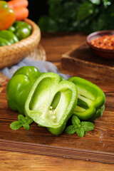 Fresh Green Bell Peppers Sliced on Wooden Board with Mint Leaves - Healthy Cooking Ingredients