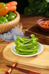 Fresh Green Edamame Beans with Colorful Sweet Peppers and Chopsticks on Wooden Kitchen Table