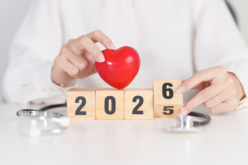 2025 end year to Happy New Year 2026 with Stethoscope of doctor and heart shape on table. health care, Insurance, Wellness and medical concepts