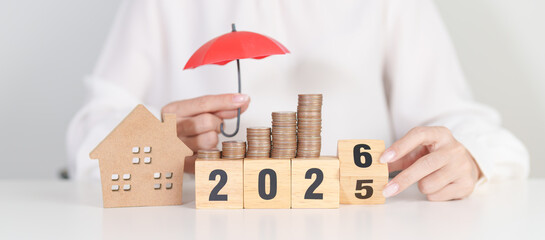 2025 end year to Happy New Year 2026 with red umbrella over money stack. Insurance, real estate,...