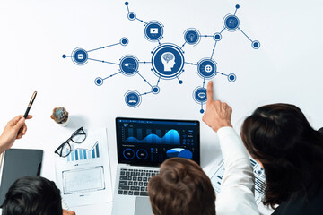 Business meeting discussing artificial intelligence strategies and data analytics with laptop and visual graphs in modern office environment. Amity