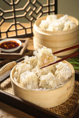 Traditional Chinese Dumplings in Bamboo Steamers with Chopsticks and Soy Sauce