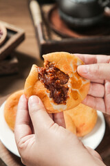 Traditional Asian Sweet Red Bean Paste Filled Steamed Bun Held in Hands