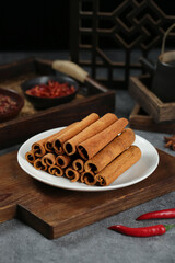 Natural Cinnamon Sticks from Guangxi China with Traditional Spice Preparation Setup on Rustic Wooden Board