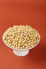 Fried Crispy Soybeans in Bowl - Traditional Guizhou Dried Snacks on Orange Background
