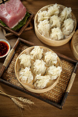 Handmade Siu Mai Dumplings in Bamboo Steamers with Pork and Sauce - Traditional Chinese Dim Sum
