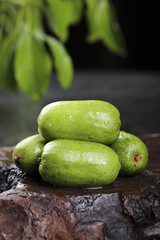 Fresh Green Kiwifruits on Dark Stone Surface with Natural Garden Background