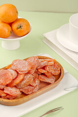 Dried Candied Orange Slices with Fresh Oranges on Green Background - Healthy Fruit Snack Concept