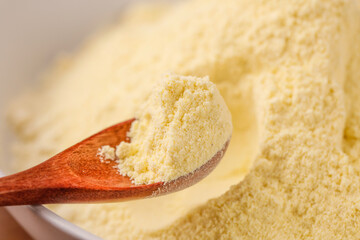 Ground Rice Flour or Grain Powder on Wooden Spoon - Fine Yellow Cooking Ingredient