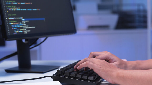 Close-up shot of IT freelancer programmer and tech engineer working with computer keyboard, hand typing software codes for application development and website network system information data in room.