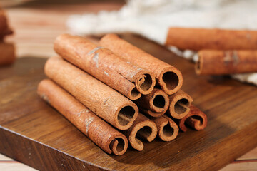 Natural Cinnamon Bark Rolls from Guangxi China on Wooden Board - Aromatic Cooking Spice Sticks