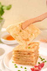 Handmade Buttermilk Pancakes with Herbs Being Served with Wooden Spatula and Syrup