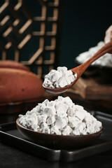 Raw white flour or starch powder in wooden bowl with spoon for handmade cooking and baking ingredients