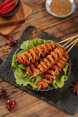 Grilled Spiced Meat Skewers on Slate Board with Fresh Lettuce Garnish