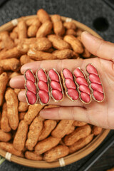 Fresh Shelled Red Peanuts in Hand with Wet Pink Kernels and Brown Skin