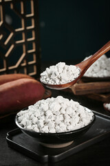 Handmade potato starch powder in rustic kitchen bowl with wooden spoon for cooking and baking