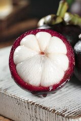 Fresh Thai Mangosteen Fruit Cut Open Showing White Flesh Segments on Wooden Background