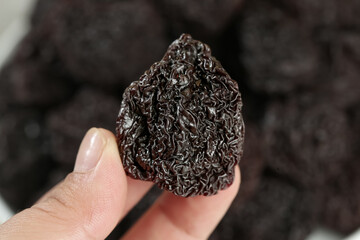 Dried Candied Plum Fruit Held in Hand - Traditional Asian Snack Food