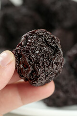 Dried Plum Fruit in Hand - Natural Healthy Snack Food Ingredient
