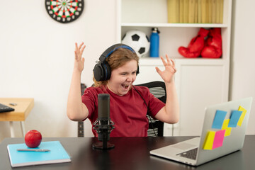 Kid recording podcast episodes with headphones. Young digital creator working on podcast. Child podcaster speaking into studio mic. Creative kid using microphone for digital projects.