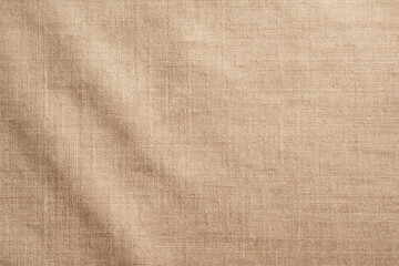 Warm beige linen fabric texture background with soft natural light and visible woven fibers, calm and organic tone