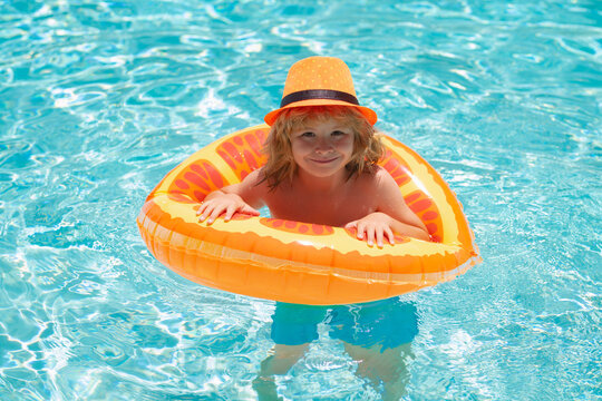 Child play in pool in summer day. Children playing in swimming pool. Summer holidays and vacation concept.