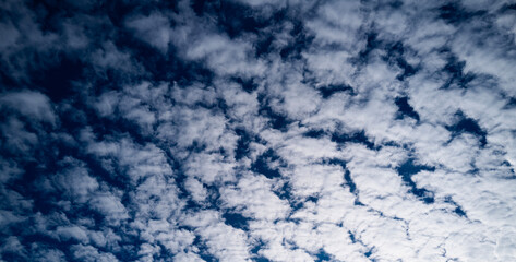 Clouds move in the blue sky. Tropical clouds at day time, white and blue. Transparent clouds layers. A clear blue sky adorned with fluffy white clouds. Calm serene cloud background.